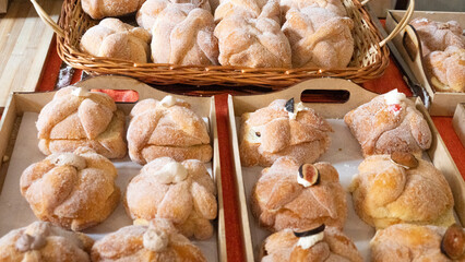 A tray of doughnuts with powdered sugar on top. The doughnuts are arranged in a basket and are of...