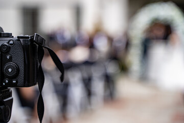View of outdoor wedding ceremony with camera in focus.