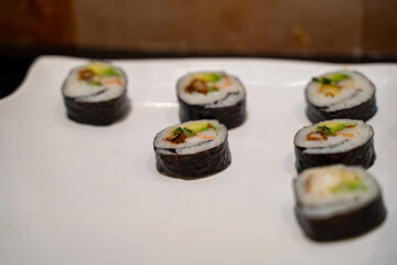 Close up of soft crab sushi rolls on white plate.