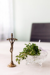 Religious wedding blessing cross with candle and holy water brush on white cloth traditional catholic christian symbol of faith and family ritual before marriage