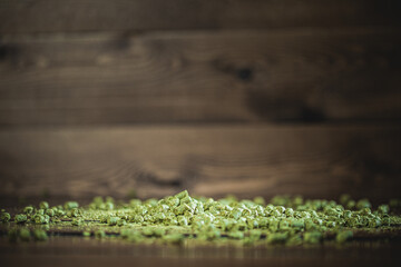 Fresh green hop cones scattered on a wooden table showcasing texture and color in a natural setting