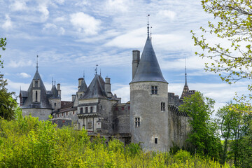 Obraz premium Chateau de La Rochepot rising above green trees in Burgundy, France