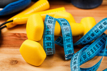 Sports equipment on a wooden table, weight loss and physical activity concept.