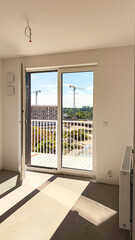 Bright room finished for sale without furniture against the background of construction and crane