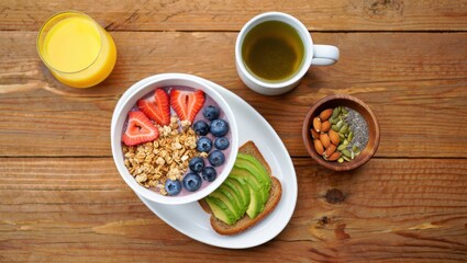 A Colorful and Nutritious Breakfast Spread Featuring Fresh Fruits, Granola, Avocado Toast, and Healthy Beverages on a Rustic Wooden Table