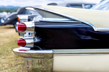 Detail of the white bask hood with the light of an American retro car. Mask of an classic old hystory veteran