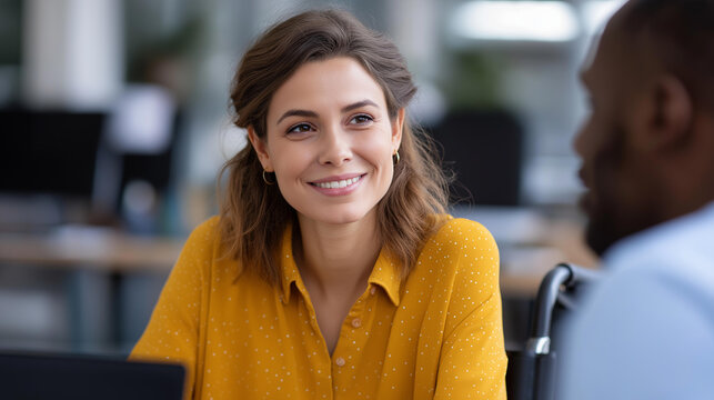 Young woman in a wheelchair collaborating with a Black male colleague on a business strategy whiteboards and coffee cups in a lively office inclusive teamwork business