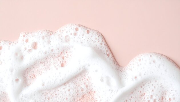 Soft, white, soapy foam swirls on a light pink background