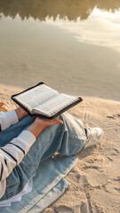 Reading the Bible by the lake on a sunny day
