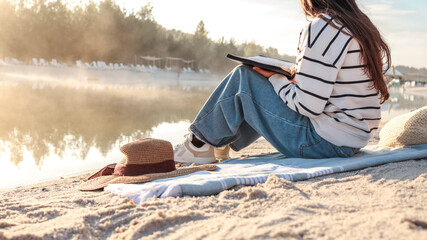 Woman reading by the lake on a sunny day