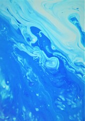 Blue abstract background. The acrylic paint flows freely and creates an interesting pattern.