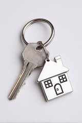 Isolated white background showing one metallic keys attached to a house-shaped keychain