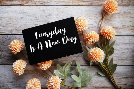 Everyday Is A New Day Motivational and Inspirational quotes with flowers bouquet decoration on wooen background