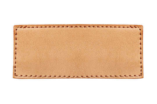 Brown leather label closeup. Rectangular leather patch isolated on white background. Jeans clothing leather detail. Fashion apparel blank leather badge for design. Closeup of stitched leather patch.
