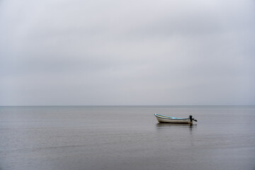 Small Boat on a Calm Sea - Minimalist Solitude on a Gray Day