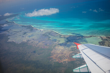 Stunning aerial view of turquoise waters and lush landscapes captured during a flight over a tropical destination