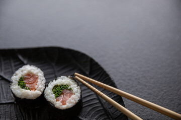 Zestaw sushi na czarnej tacy w kształcie liścia Assorted sushi on a black leaf-shaped tray