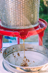Apple juice extraction process using a hydropress strainer in a rural setting during late afternoon