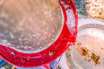 Local artisan demonstrates traditional processing technique for fresh juice at community fair in summer afternoon