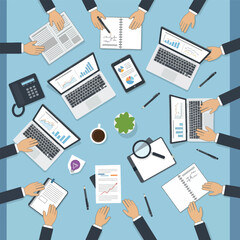Overhead view of a business meeting with laptops and financial documents