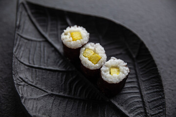 Zestaw sushi na czarnej tacy w kształcie liścia Assorted sushi on a black leaf-shaped tray