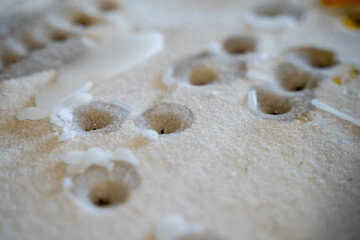 Melted candle wax dripped on sand in a church prayer area.