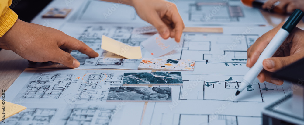 Aufkleber hands engage in collaborative brainstorming over architectural plans and sketches, showcasing teamwo
