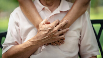 Elderly hands share a tender embrace and support encouraging old people symbolizing enduring love connection and devoted partnership in a serene outdoor environment, Elderly health care concept