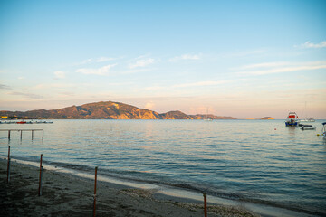 Laganas Bay Zakynthos Greece calm blue sea with mountains in the background at golden hour sunlight reflecting on the peaceful water surface