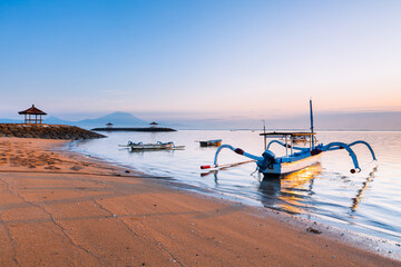 Scenic panorama of Sanur beach at sunrise with a volcano on the background, Bali, Indonesia