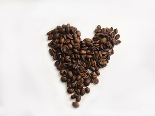 Heart shape made of coffee beans on white background