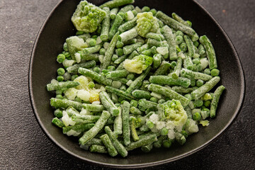 Frozen green vegetables green peas, broccoli, string beans, kohlrabi kale tasty snack fresh gourmet food background on the table rustic food top view copy space vegan and vegetarian food