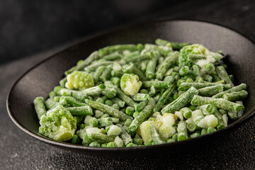 Frozen green vegetables green peas, broccoli, string beans, kohlrabi kale tasty snack fresh gourmet food background on the table rustic food top view copy space vegan and vegetarian food