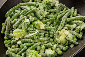 Frozen green vegetables green peas, broccoli, string beans, kohlrabi kale tasty snack fresh gourmet food background on the table rustic food top view copy space vegan and vegetarian food
