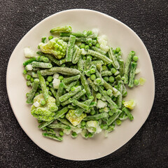 Frozen green vegetables green peas, broccoli, string beans, kohlrabi kale tasty snack fresh gourmet food background on the table rustic food top view copy space vegan and vegetarian food