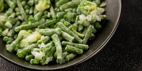 Frozen green vegetables green peas, broccoli, string beans, kohlrabi kale tasty snack fresh gourmet food background on the table rustic food top view copy space vegan and vegetarian food