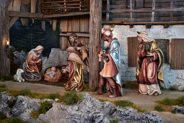 Weihnachtskrippe im alpenländischen, ländlichen Stil, mit Bergen und Nachthimmel als Hintergrund,...