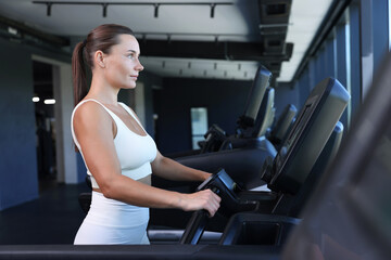 Fototapeta premium Athletic woman training on treadmill in gym