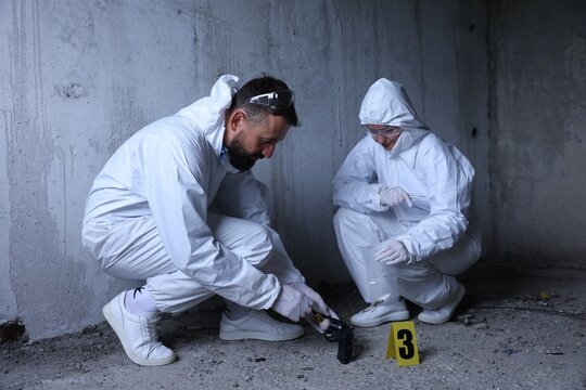 Forensic experts working at crime scene inside abandoned building