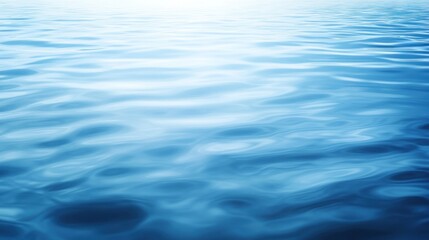 Obraz premium Blue water surface with soft ripples and light reflections