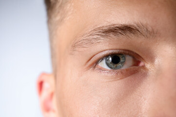 Fototapeta premium Man with beautiful eyes on light grey background, closeup