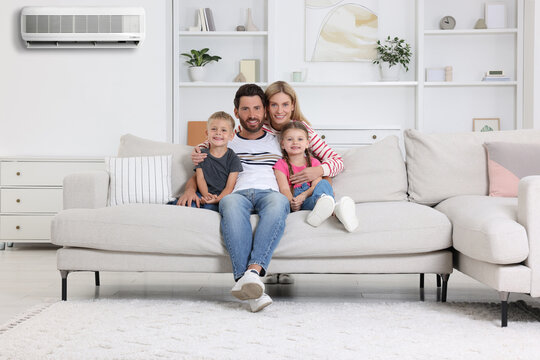 Happy family with children at home. Air conditioner keeping comfortable temperature in room