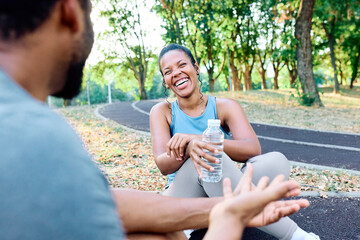 Smiling active young couple jogging exercising and having fun and holding a bottle of water together taking a break after walking and running in the park, fitness and healhty living concept