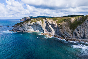 Atlantic coast and ocean. Rocks on the coastline. View from above. Blue sky with clouds. Seascape