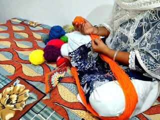 brown hands crocheting colorful yarn. multicolor yarn wool textured pattern for crochet. colorful...