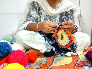 brown hands crocheting colorful yarn. multicolor yarn wool textured pattern for crochet. colorful...