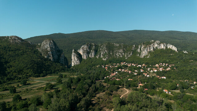 Aerial view of Jerma Canyon in Serbia with a small village surrounded by rocky cliffs and green forest