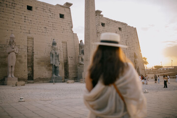 Turista en el Templo de Lúxor con obelisco y estatuas monumentales, Egipto