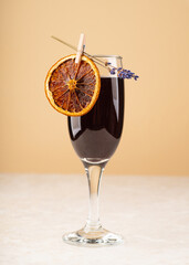 Champagne based black cocktail decorated with lavender flowers and dried orange. Halloween cocktail.