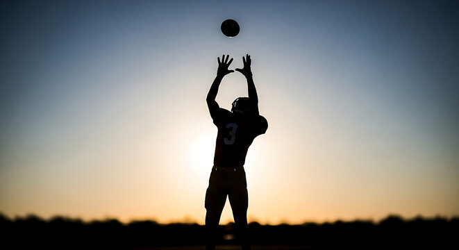 American football player silhouette catching a ball at sunset with goal of scoring touchdown